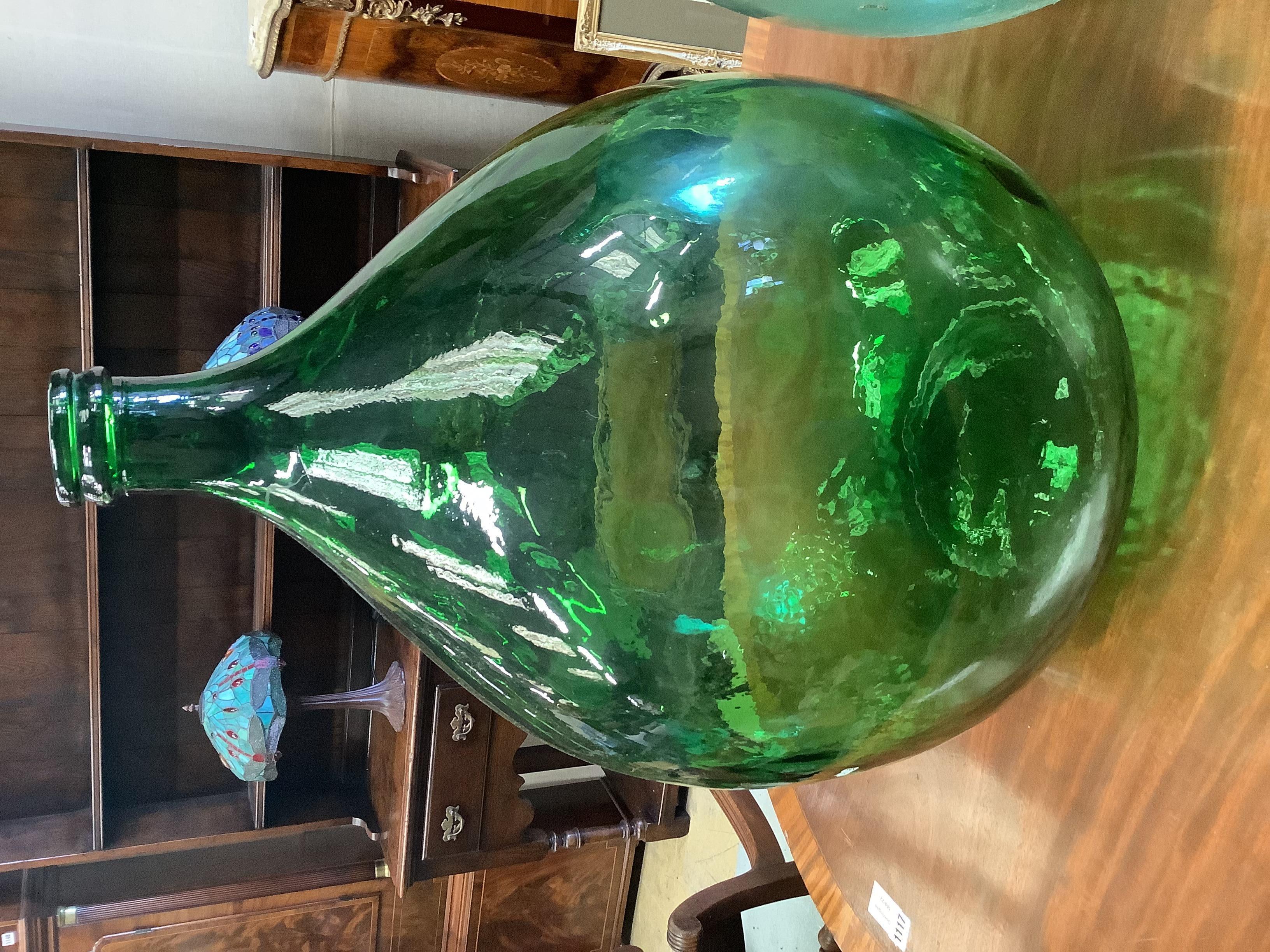 A pair of green glass carboys, height 62cm